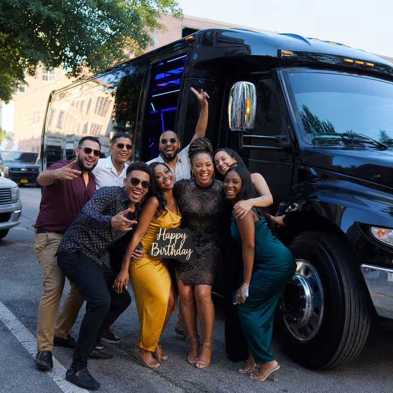 Group boarding a white charter bus for Birthday Transportation transportation in Colorado Springs