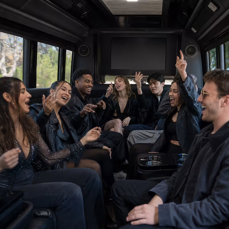Group boarding a white charter bus for Concert Transportation transportation in Colorado Springs