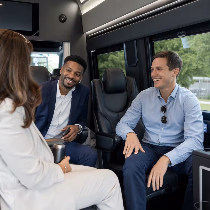 Group boarding a white charter bus for Corporate Transportation transportation in Colorado Springs