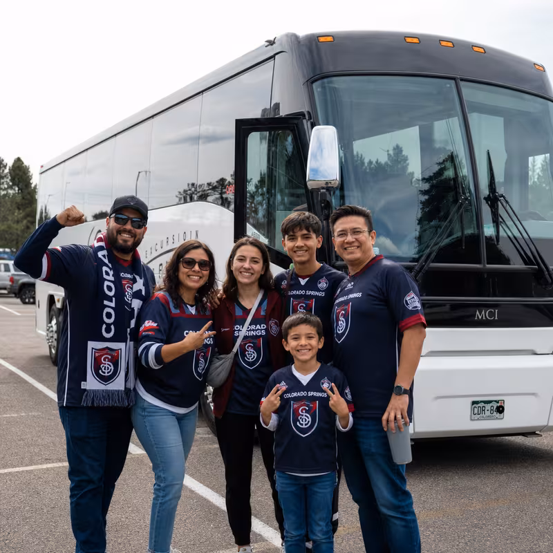 Passengers loading luggage while boarding an Colorado Springs group shuttle