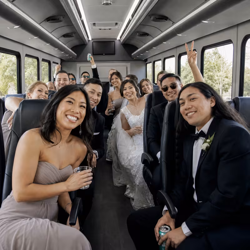 Group boarding a white charter bus for Wedding Transportation transportation in Colorado Springs